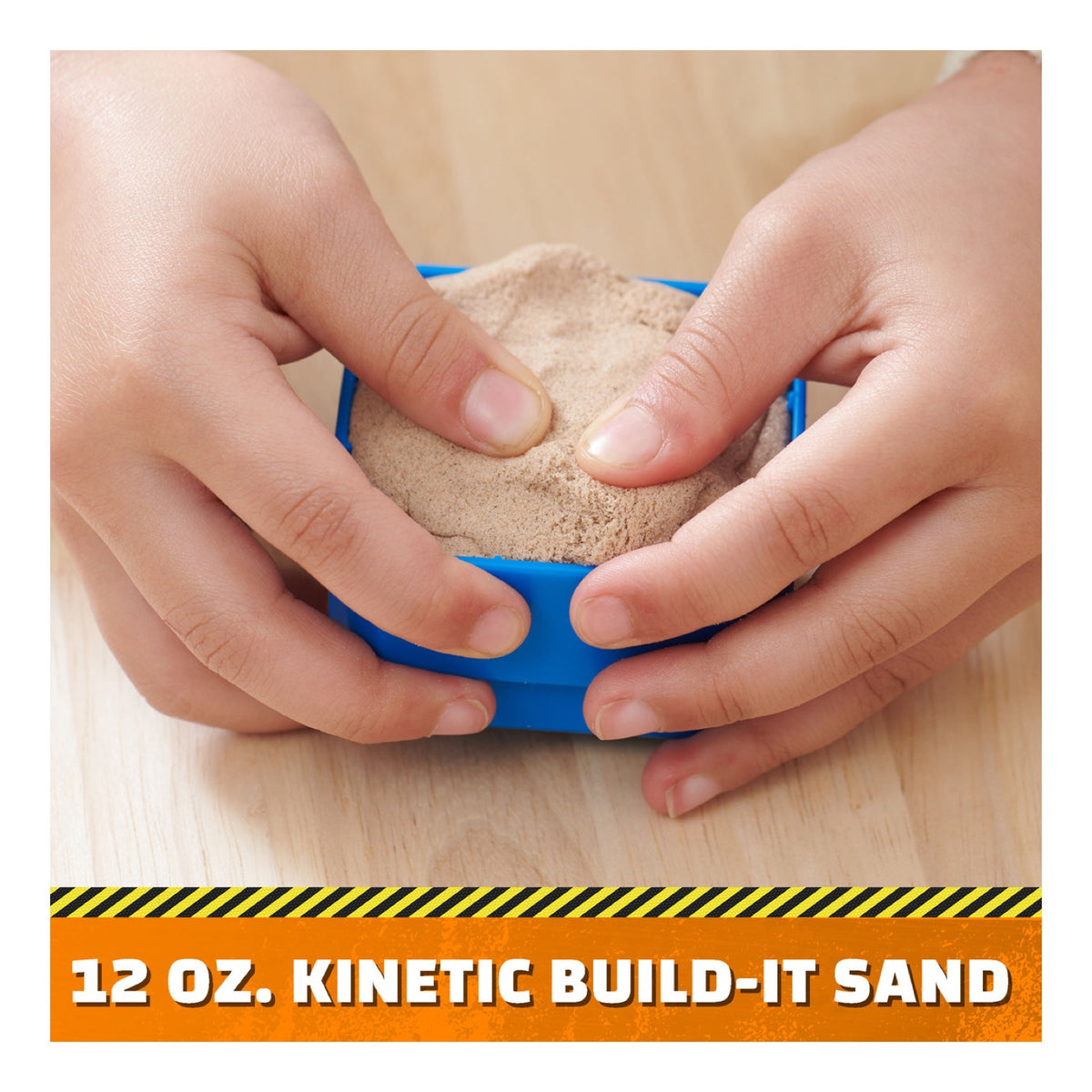 Child shaping the included kinetic sand in a blue mould