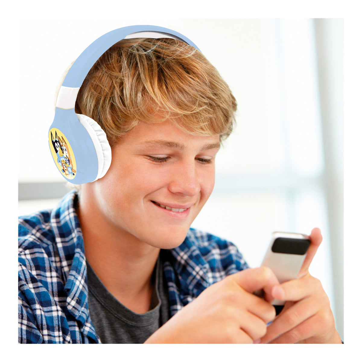 Teenage boy wearing Bluey headphones while using a phone