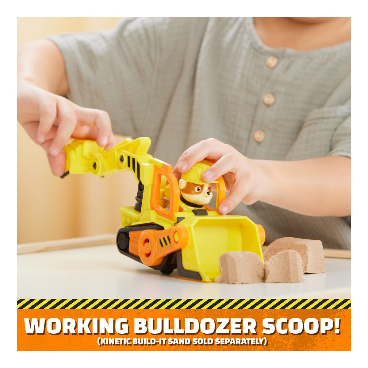 Child using the working scoop on Rubble's yellow bulldozer
