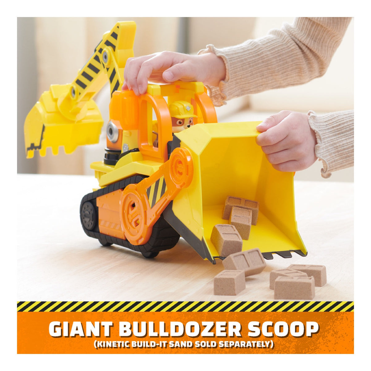 Child using the bulldozer’s large front scoop to collect building blocks