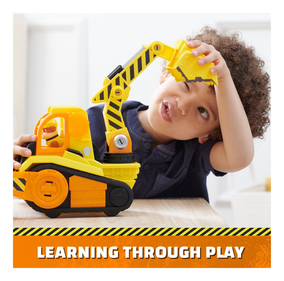 Child playing with the articulated excavator arm on Rubble’s bulldozer