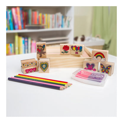 Wooden friendship stamps, coloured pencils and ink pad displayed with the storage tray