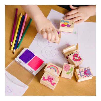 Child using the wooden friendship stamps with ink and coloured pencils