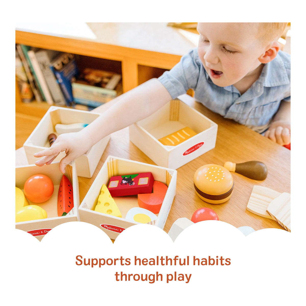 Child playing with wooden food pieces and sorting crates