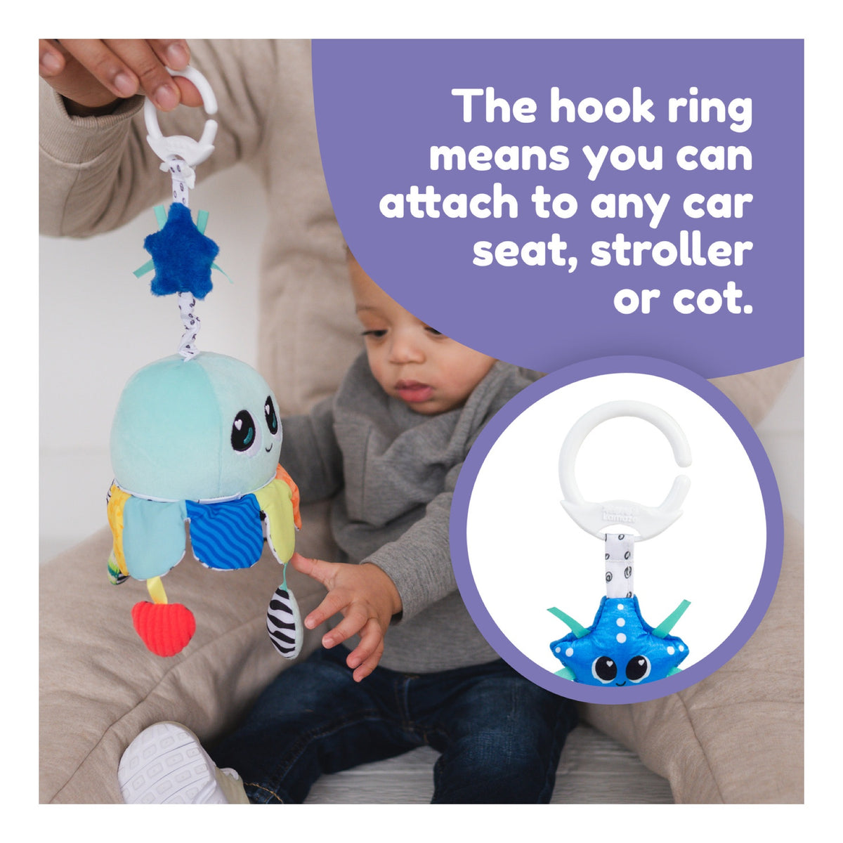 Salty Sam stroller toy attached by its hook ring beside a baby