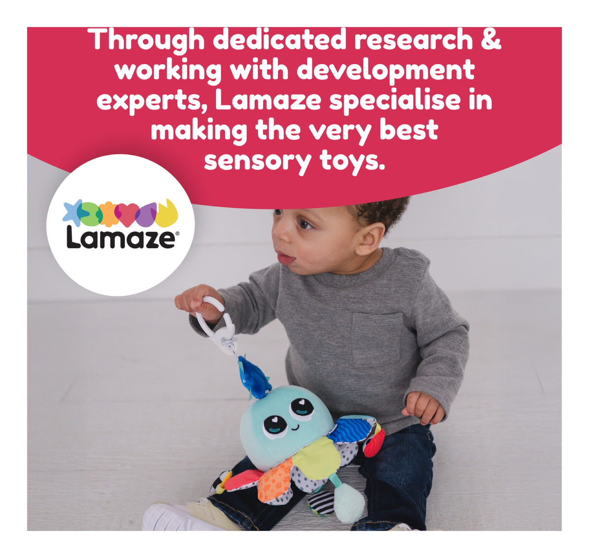 Baby holding the colourful Lamaze Salty Sam sensory toy