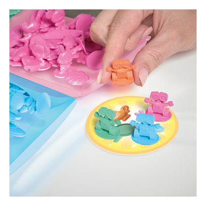 Hand placing a Disney character piece on a yellow All 4 Won! play disc