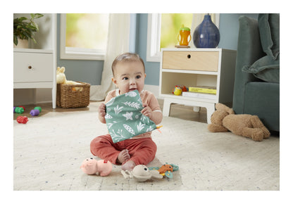 Baby holding the green Sensimals crinkle panel