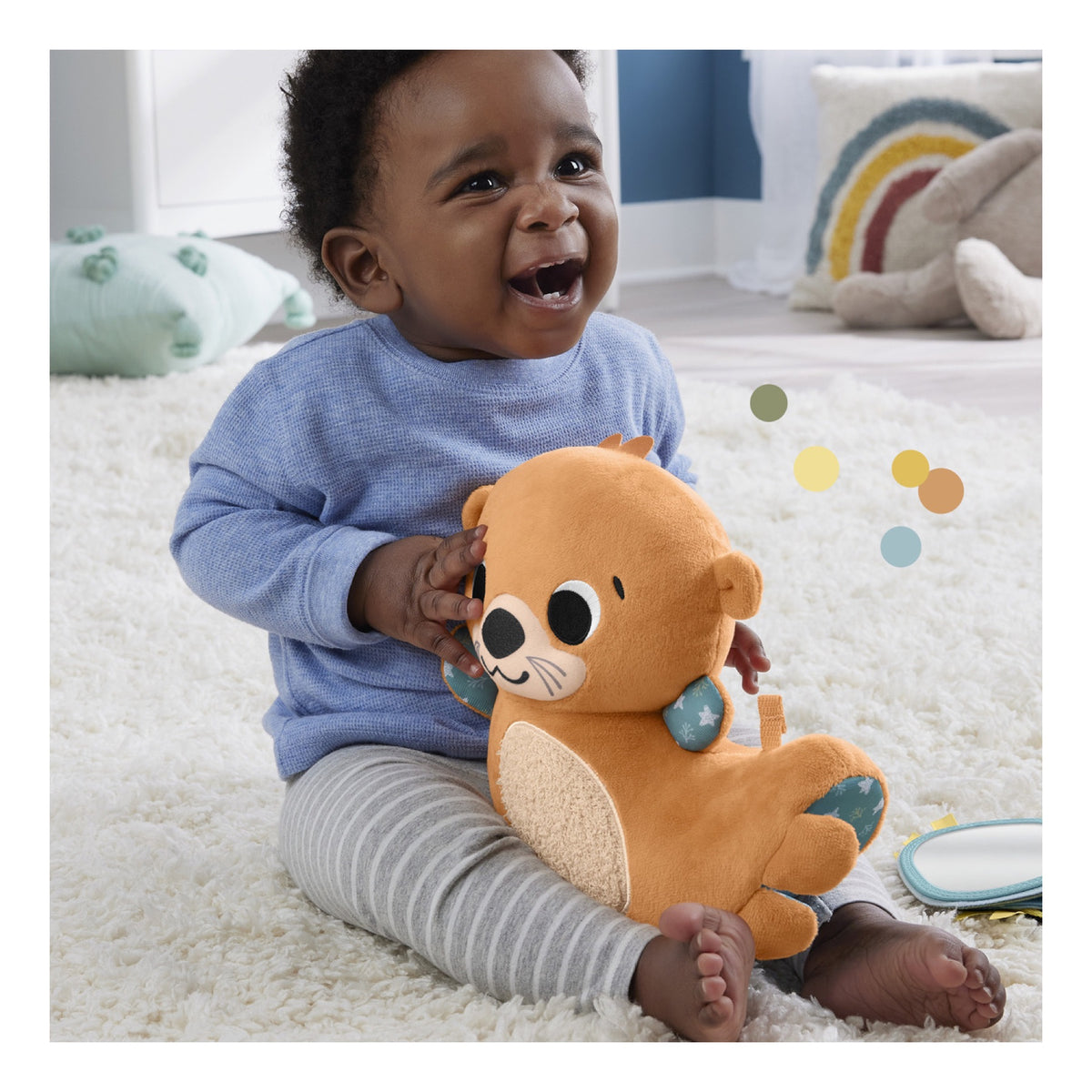 Smiling baby holding the rocking otter plush sensory toy