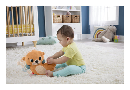 Baby sitting on a rug and playing with the rocking otter sensory toy